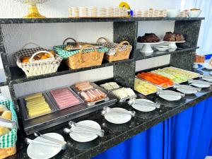 a buffet with plates and other food on a table at Pousada Maravista in Cananéia