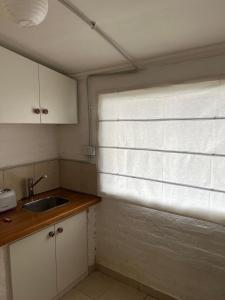 a kitchen with a sink and a window with blinds at MAITEN Esquel in Esquel