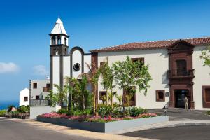 a church with a clock tower in front of a street at Hacienda del Conde member of Meliá Collection - Adults Only in Buenavista del Norte