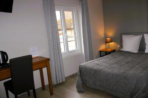 Arcis-sur-Aubeにあるle saint Hubertのベッドルーム1室(ベッド1台、デスク、窓付)