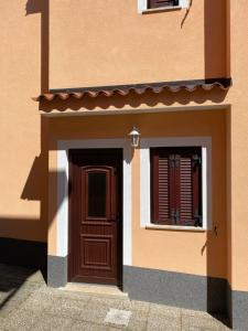 a building with a wooden door and a window at Apartments Nadia Umag in Umag