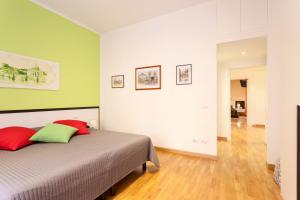 ローマにあるCasa Vacanze "Sognando Roma"のベッドルーム1室(赤と緑の枕が備わるベッド1台付)