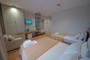 a hotel room with two beds and a tv at Hotel Ajden by Mira Mare in Ksamil