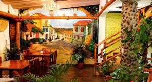 een restaurant met een schilderij van een straat bij Hotel Maderanegra By Huasicama in Latacunga