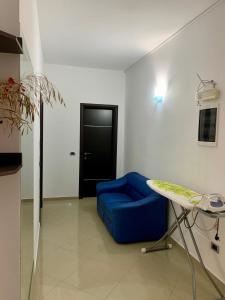 Habitación con sofá azul y puerta negra en Hotel Piazza, en Sarandë