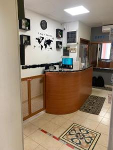 a lobby with a counter with a clock on the wall at Hotel Mercurio in Milan