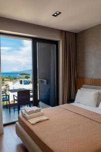 a bedroom with a bed and a balcony with a view at Hotel Ajden by Mira Mare in Ksamil