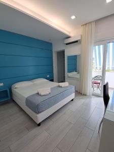 a bedroom with a bed and a blue wall at Dreams Tropea Mare "Parking Private" in Tropea
