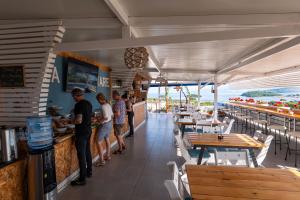 a group of people standing at the counter of a restaurant at Hotel Ajden by Mira Mare in Ksamil