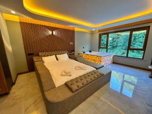 um quarto com uma cama grande e uma janela grande em TUVA VİLLA Bungalov em Çamlıhemşin
