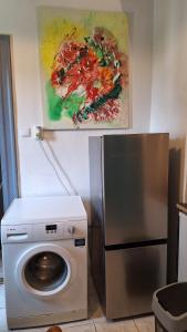 una cucina con lavatrice e un dipinto sul muro di Great Buda Apartman a Budapest
