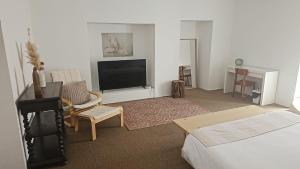 a hotel room with a bed and a tv and a room at ZN Lodge in Vidago