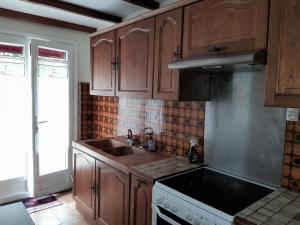 eine Küche mit Holzschränken und einer Spüle in der Unterkunft Gîte au cœur des châteaux de la loire in Lignières-de-Touraine + 3 Fotos