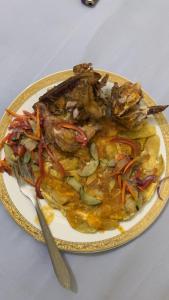 un piatto di cibo su un tavolo con un coltello di G & S Executive Lodge a Dar es Salaam