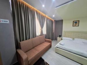 a bedroom with a bed and a couch and a window at CityCenterHotel Shkoder in Shkodër