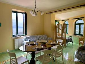 a living room with a table and chairs and a couch at Smeraldo Holiday in Maratea