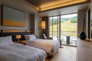 a hotel room with two beds and a large window at Fenix Furano in Furano +111 photos