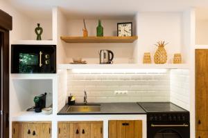 a kitchen with a sink and a microwave at Dunas Luxury Beach Resort Tarifa in Tarifa