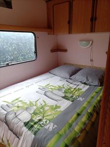Mobil home inter في بيرك سور مير: سرير في وسط غرفة مع نافذة