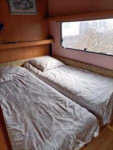 Cama en habitación pequeña con ventana en Mobil home inter, en Berck-sur-Mer