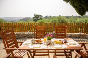 a wooden table with plates of food on it at liofito village house in Pemónia