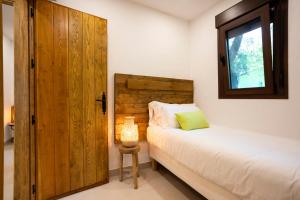 Schlafzimmer mit einem Bett und einer Holztür in der Unterkunft Dunas Luxury Beach Resort Tarifa in Tarifa