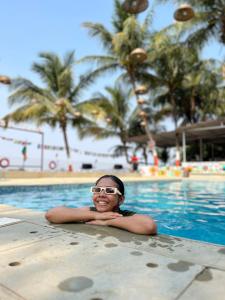 een jong meisje ligt in een zwembad bij Off The Grid Glamps in Khopoli