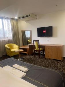 a hotel room with a bed and a tv on the wall at Hotel 5092 in Abuja