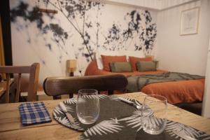 a wooden table with two glasses on top of it at Les Cocons d AleXan Le studio balnéo aromathérapie in Quinssaines