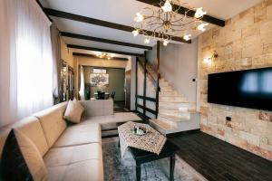 Villas Lirtzis في تاكسيارشيس: غرفة معيشة مع أريكة وتلفزيون