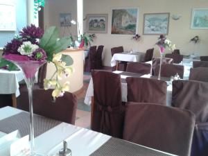 a restaurant with tables and chairs with flowers on them at Hotel Vila Anna in Trenčianske Teplice