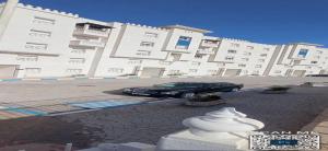 a black car parked in front of a large building at Appartement a louer au Nord du maroc fnideq in Fnidek