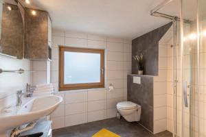 une salle de bain avec un lavabo et des toilettes et une fenêtre dans l'établissement Familien - 3 SZ - Terrasse mit Bergblick - 2 Parkplätze, à Fügen