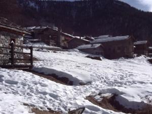 un villaggio innevato con case e edifici di Luminoso monolocale panoramico a La Magdeleine Altre 4 foto