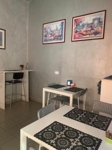a room with white tables and chairs and pictures on the wall at Hotel Mercurio in Milan