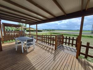 a wooden deck with a table and chairs on it at Agriturismo Alturetta in Riotorto