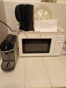 a microwave with a piece of paper on top of it at Annexe indépendante in Bourron-Marlotte