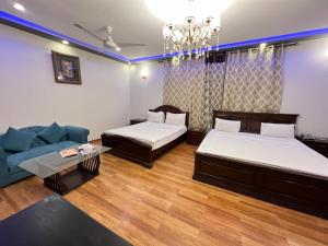 uma sala de estar com duas camas e um sofá em Family lodges em Islamabad