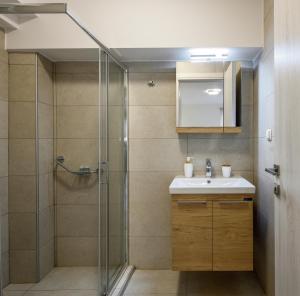 a bathroom with a shower and a sink at Elpiniki Luxury Rooms in Nea Potidaea
