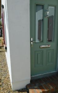 una puerta verde con una ventana en una casa en Willow Cottage Accommodation en Sligo