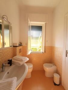 a bathroom with a sink and a toilet and a window at Villa bruna in Sori