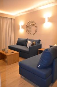 uma sala de estar com um sofá azul e uma mesa em Odysseus Hotel em Paleokastritsa