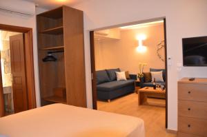 Habitación con sofá y sala de estar con espejo. en Odysseus Hotel en Paleokastritsa