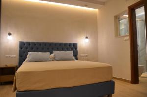 帕萊歐卡斯提撒的住宿－奧德修斯酒店，一间卧室配有一张大床和蓝色床头板