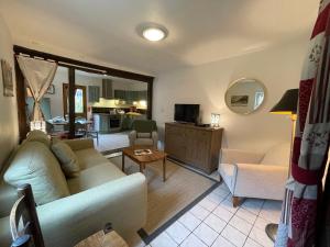 ein Wohnzimmer mit einem Sofa und einem Tisch in der Unterkunft Le Douet Fleury - Gîte de Jardin in Livarot