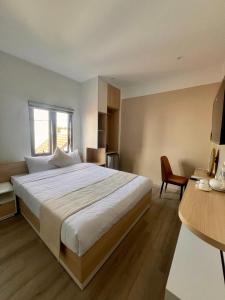 una camera da letto con un grande letto bianco e una sedia di Hoang Thang 1 Hotel Da Lat City a Da Lat