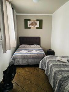 Un dormitorio con 2 camas y una silla. en HOSTEL ANPRADO en Guarulhos