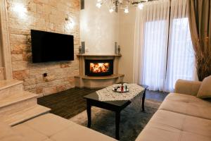 sala de estar con chimenea y TV en Villas Lirtzis, en Taxiarchis