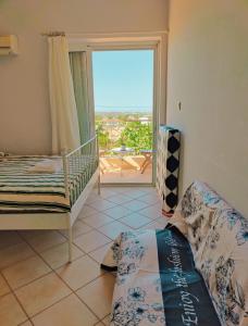 um quarto com uma cama e uma janela com vista em Artemis Cinema Garden Near Airport & Sea em Artemida
