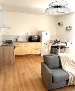 a living room with a chair and a kitchen at Appartement calme , 400m de la gare in Saint-Brieuc